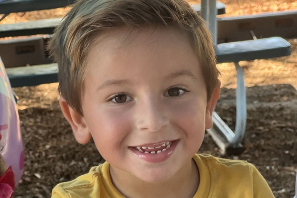 a young male student smiling outside